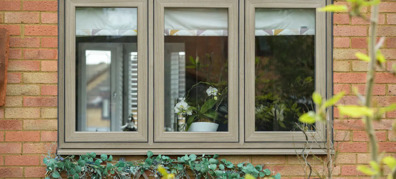 Woodgrain uPVC flush sash windows on a brick cottage
