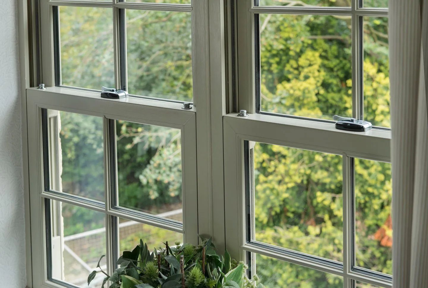 Sage green uPVC sliding sash windows with Georgian bars