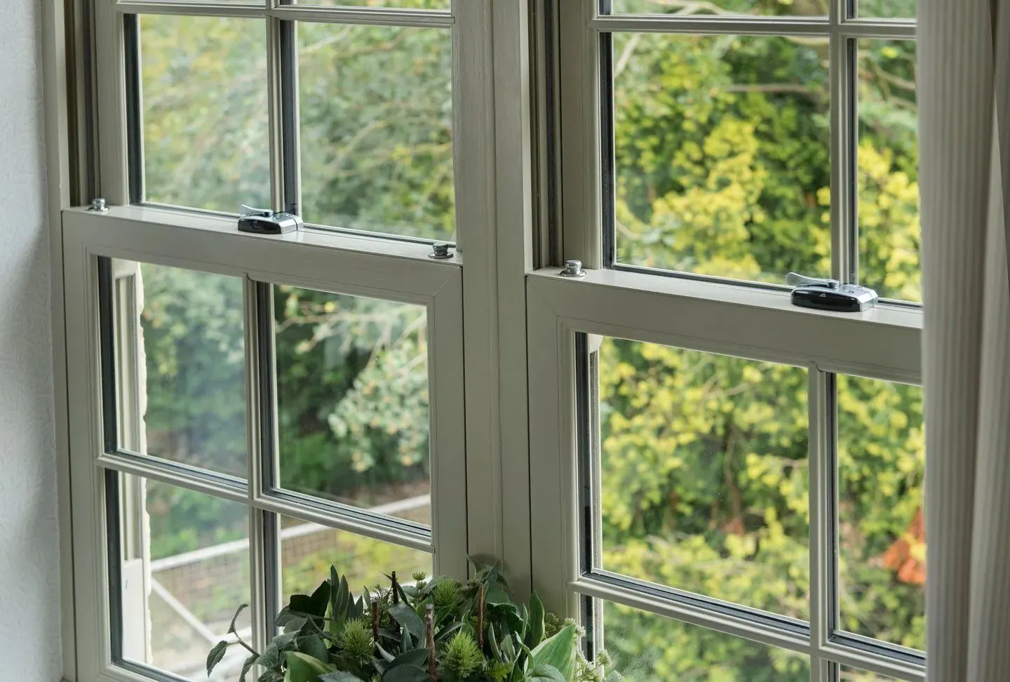 Sage green uPVC sliding sash windows with Georgian bars